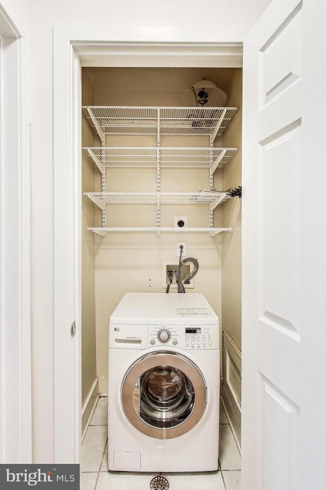 laundry room with washer / dryer and light tile patterned flooring