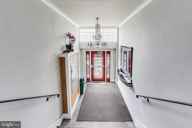 interior space featuring ornamental molding, carpet floors, and a chandelier