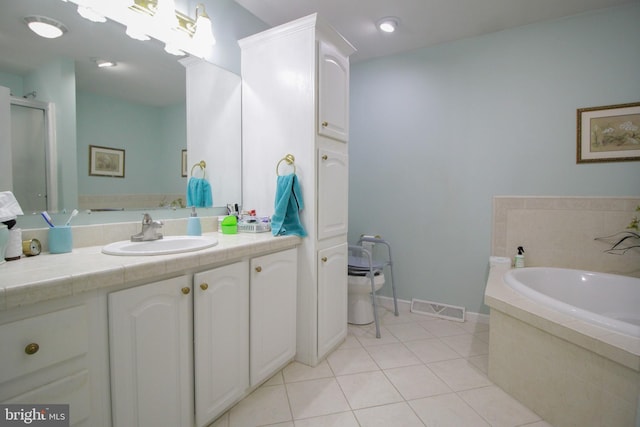 bathroom featuring vanity, tile patterned flooring, and tiled bath
