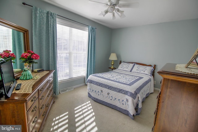 bedroom with multiple windows, light carpet, and ceiling fan