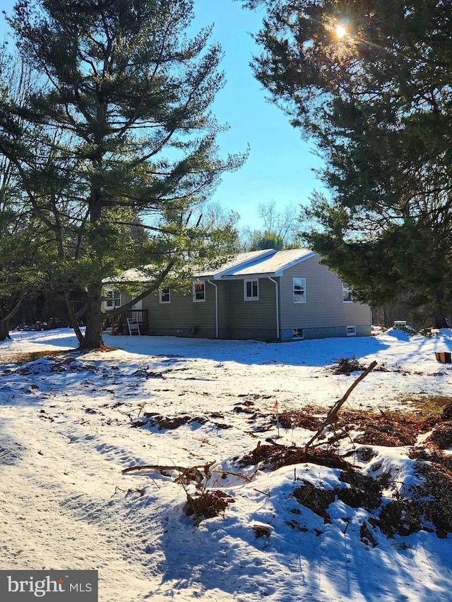 view of snow covered back of property