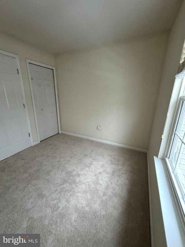 unfurnished bedroom featuring a closet and carpet flooring