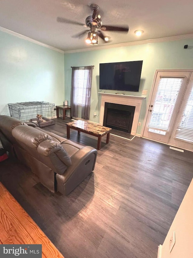 living room with hardwood / wood-style flooring, ceiling fan, and crown molding