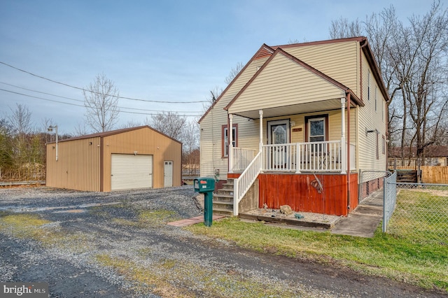 view of front of house featuring a garage, an outdoor structure, and covered porch