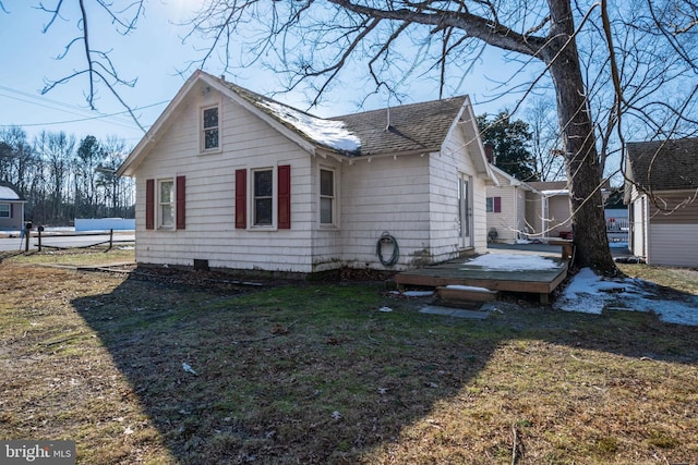 view of home's exterior featuring a wooden deck and a lawn