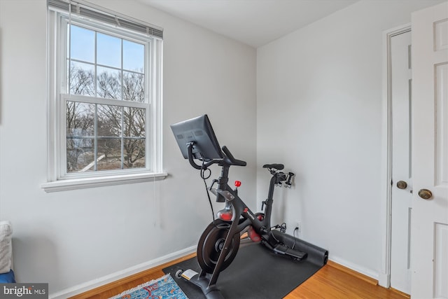 workout area with baseboards and wood finished floors