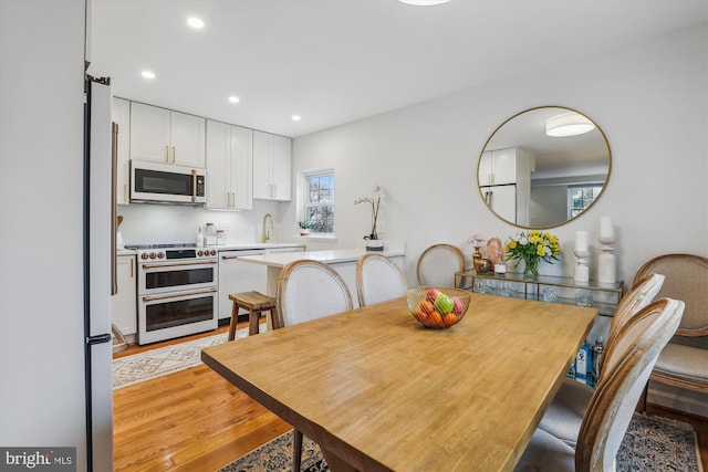 dining room featuring light wood-style flooring and recessed lighting