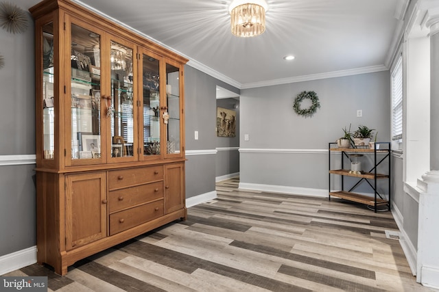 dining area with a notable chandelier, wood-type flooring, and ornamental molding