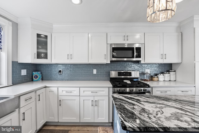 kitchen with stainless steel appliances, decorative backsplash, and white cabinets