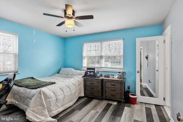 bedroom featuring multiple windows, hardwood / wood-style flooring, and ceiling fan