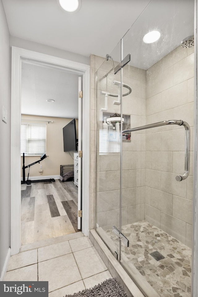 bathroom featuring a shower with shower door and tile patterned floors