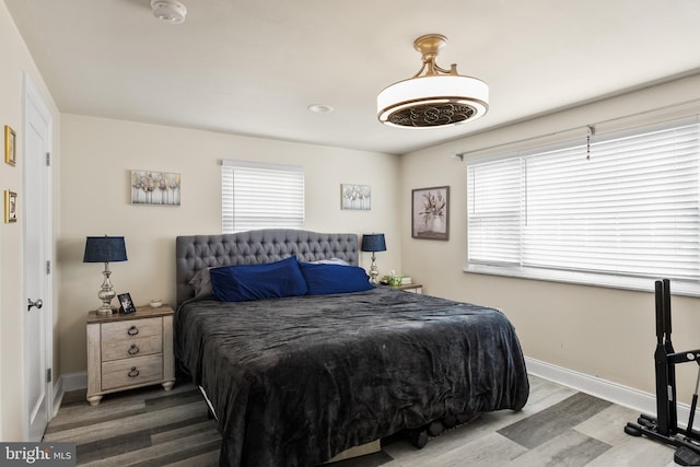 bedroom featuring multiple windows and hardwood / wood-style floors