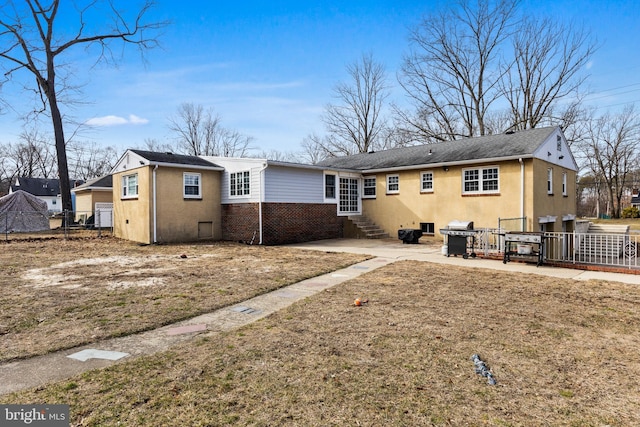 rear view of property with a yard and a patio