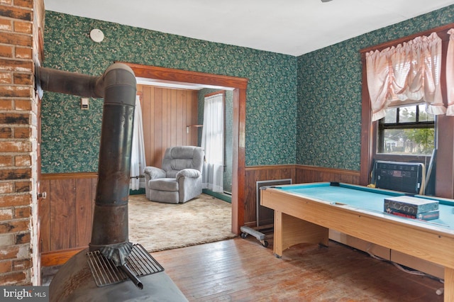 game room featuring hardwood / wood-style flooring and a wood stove