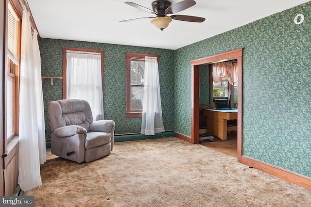 living area with ceiling fan and carpet