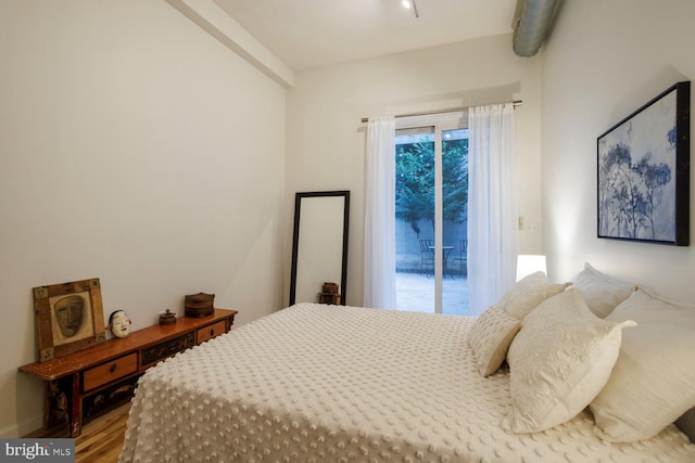 bedroom with hardwood / wood-style floors and access to outside