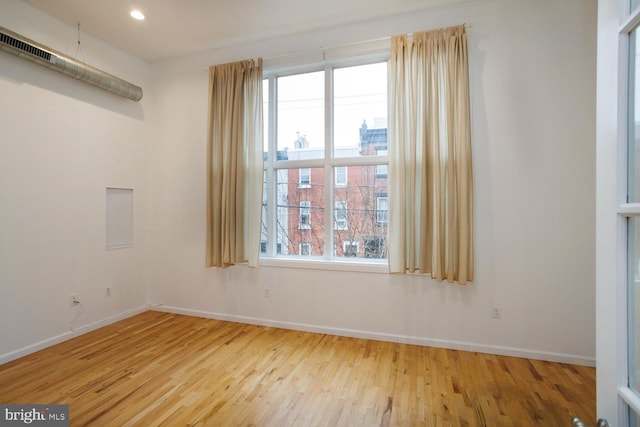 spare room with light hardwood / wood-style floors and a healthy amount of sunlight