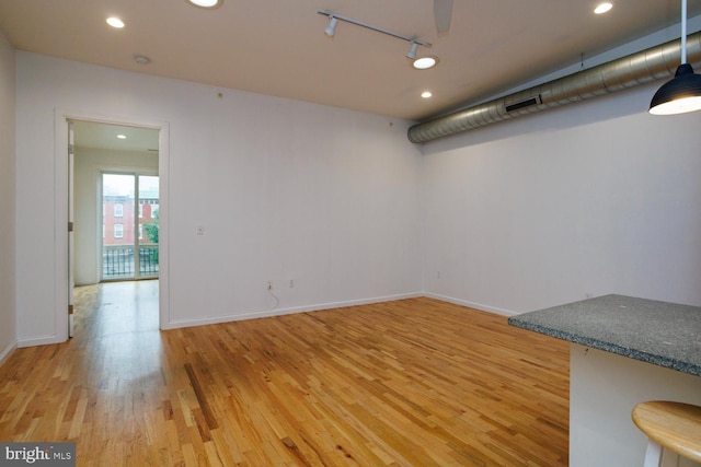 spare room featuring hardwood / wood-style flooring and rail lighting