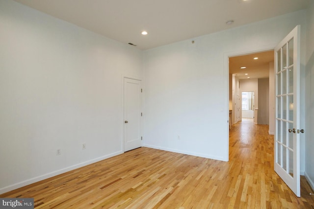 empty room featuring light hardwood / wood-style flooring and french doors