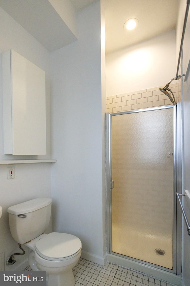 bathroom with a shower with door, tile patterned flooring, and toilet