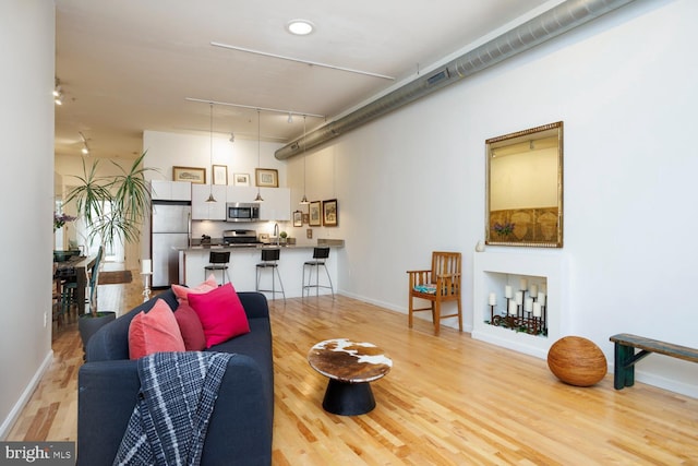 living room featuring sink and light hardwood / wood-style flooring