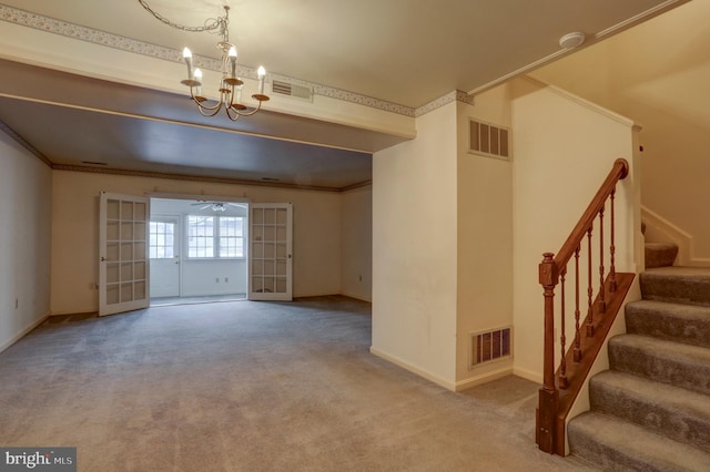 unfurnished living room with french doors, ornamental molding, carpet, and a notable chandelier