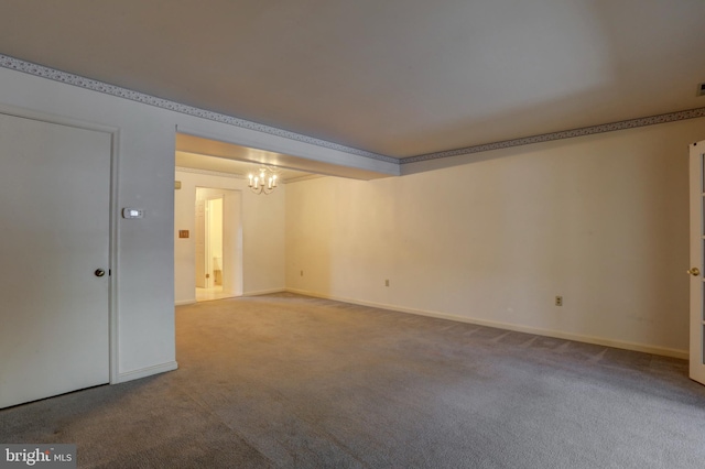 carpeted spare room with ornamental molding and a chandelier