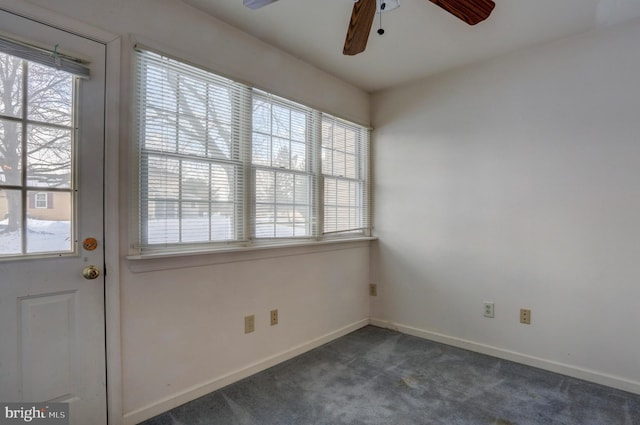 interior space with ceiling fan and dark colored carpet