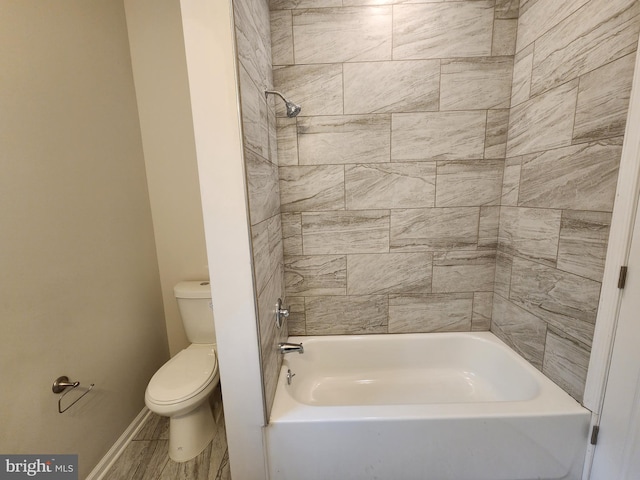 bathroom with toilet and tiled shower / bath combo