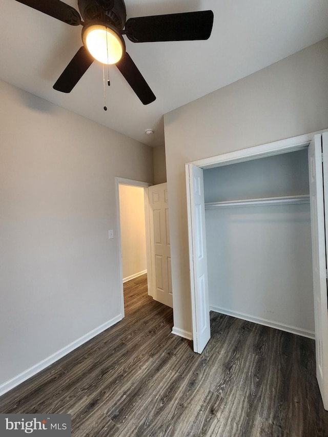 unfurnished bedroom featuring a closet, dark hardwood / wood-style floors, and ceiling fan