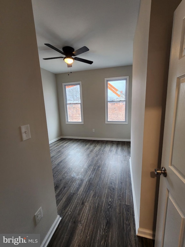 spare room featuring dark wood-type flooring and ceiling fan