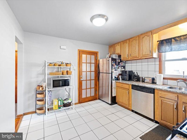 kitchen featuring tasteful backsplash, appliances with stainless steel finishes, sink, and light tile patterned floors