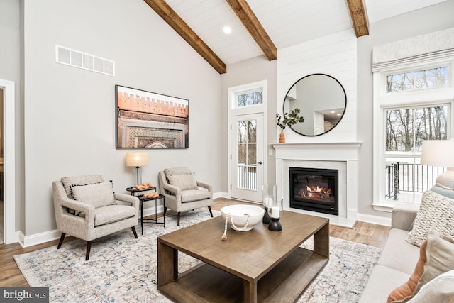 living room featuring beam ceiling, high vaulted ceiling, light hardwood / wood-style floors, and wooden ceiling