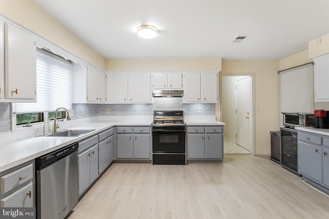 kitchen with range with gas stovetop, sink, gray cabinets, and stainless steel dishwasher