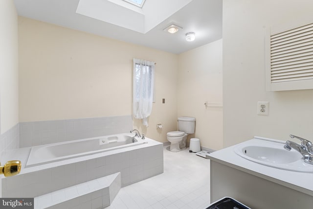 bathroom with a skylight, vanity, a relaxing tiled tub, and toilet