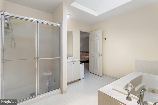 bathroom with vanity, a skylight, tile patterned floors, and separate shower and tub