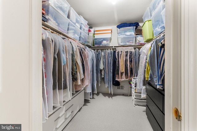 walk in closet featuring light carpet