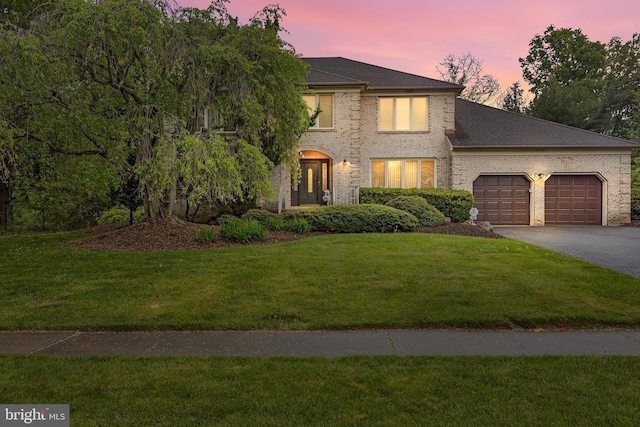 view of front of property with a yard and a garage