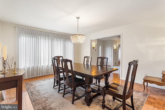 dining room with parquet flooring and a chandelier