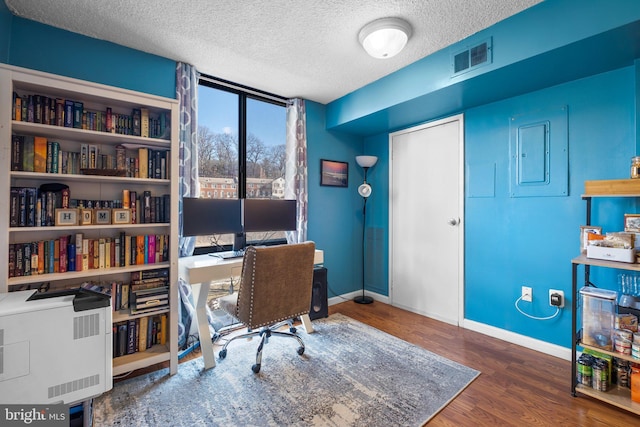 home office featuring hardwood / wood-style floors and a textured ceiling