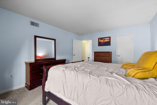 bedroom featuring light carpet and a textured ceiling