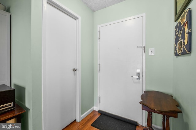 foyer entrance featuring a textured ceiling and light hardwood / wood-style floors