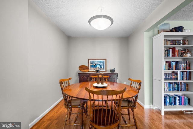 dining room with hardwood / wood-style flooring and a textured ceiling