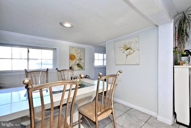 tiled dining space with plenty of natural light and ornamental molding