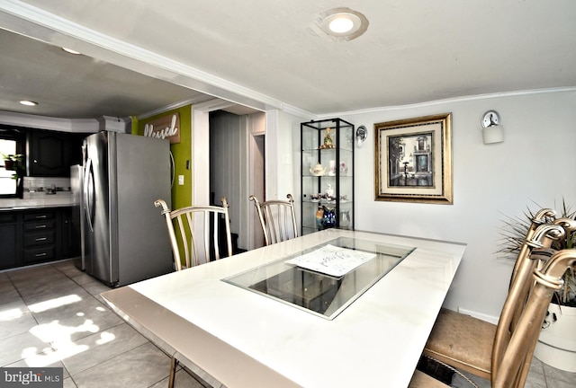 tiled dining area featuring crown molding