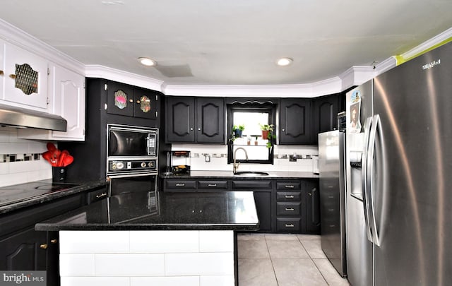 kitchen featuring sink, light tile patterned floors, tasteful backsplash, black appliances, and dark stone counters