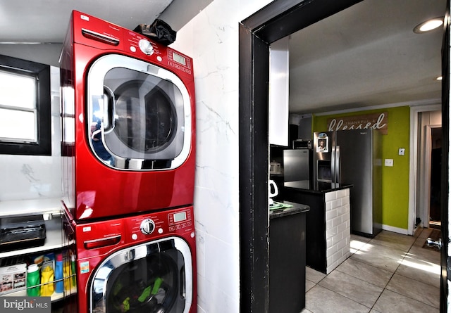 washroom with stacked washer and dryer and light tile patterned flooring