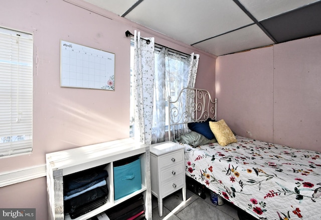 bedroom with multiple windows and a drop ceiling