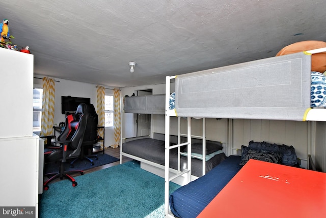 bedroom featuring white refrigerator