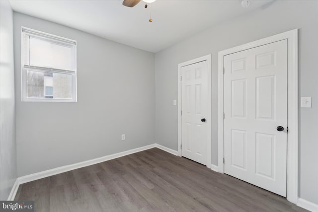 unfurnished bedroom featuring dark wood-type flooring and ceiling fan